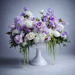 Lavender and white floral arrangement in a white pedestal vase