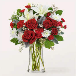 Red roses and white lilies in a clear glass vase