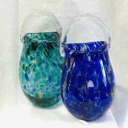Two small glass pitchers with clear handles, one teal and one blue.