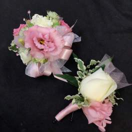 Two pink and white floral boutonnieres with ribbon accents
