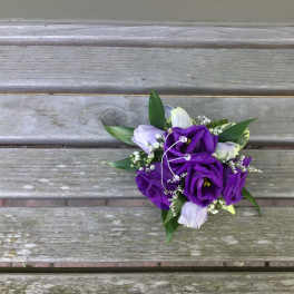 Small bouquet of purple and white flowers with greenery