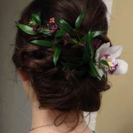 Floral hairpiece with white orchid blooms and purple accents in dark hair