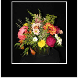 Mixed bouquet in a clear glass vase with pink, yellow, and orange blooms