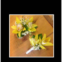 Two yellow orchid boutonnieres with white ribbon and small white accents