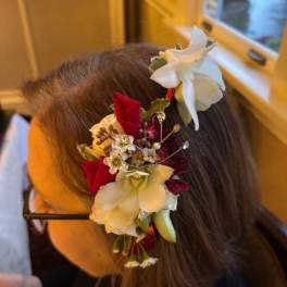 Floral hair accessory with white and red flowers worn in the hair