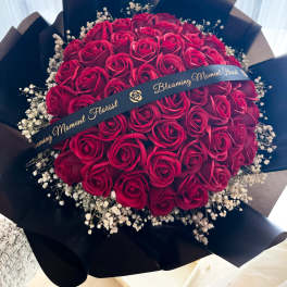 Bouquet of red roses with baby's breath in black wrap