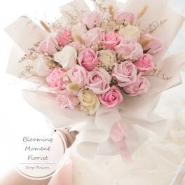 Bouquet of pink and white roses wrapped in pale paper
