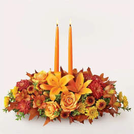 Autumn floral centerpiece with two orange taper candles