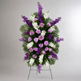 Standing floral spray with purple and white flowers on an easel