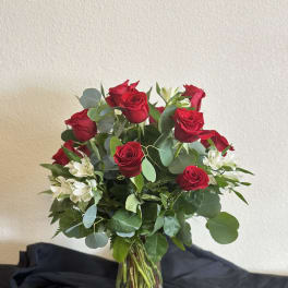 Red roses and white alstroemeria in a clear glass vase