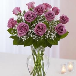 Lavender roses in a clear glass vase with baby's breath