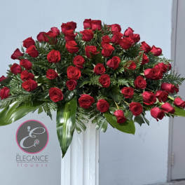 Large arrangement of red roses on a white pedestal