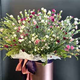 Large bouquet of pink, white, and burgundy carnations in a pink hat box