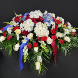 Large floral spray with red and white roses, hydrangeas, and daisies