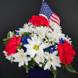 Red, white, and blue flower arrangement with an American flag
