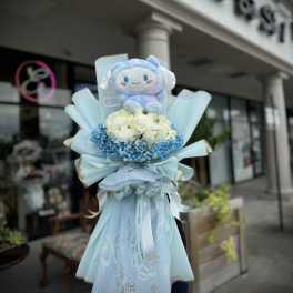 Blue and white bouquet with a plush character topper and ribbon wrap