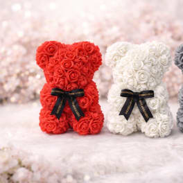 Three rose-covered teddy bears in red, white, and gray with black ribbons