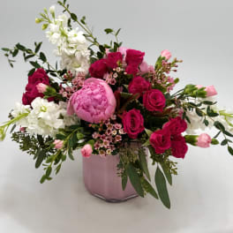 Pink and white floral arrangement in a pink vase