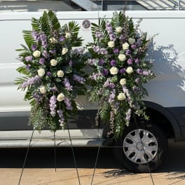 Two large floral standing sprays with white roses and lavender flowers