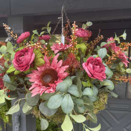 Hanging floral basket with bright pink blooms and eucalyptus