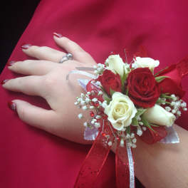 Hand corsage with red and white roses on a red dress