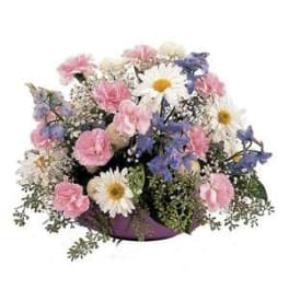 Mixed bouquet of pink, white, and purple flowers in a purple container