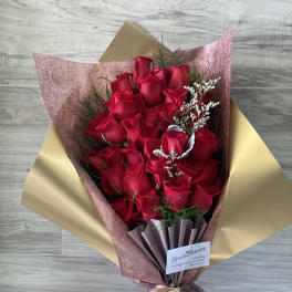 Bouquet of red roses wrapped in pink and gold paper