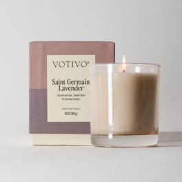 Lit lavender-scented candle in a glass tumbler beside its box