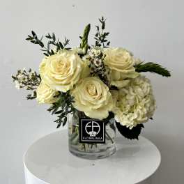 Cream rose bouquet with white hydrangea in a clear glass vase
