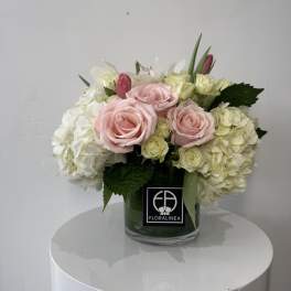 Pink roses and white hydrangeas arranged in a glass vase