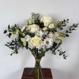 Bouquet of white roses and daisies with eucalyptus in a tied hand wrap