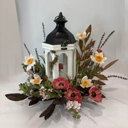 Floral arrangement around a white lantern with pink and white flowers