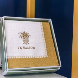 Boxed napkins with a gold pineapple logo and trim