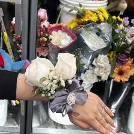 White rose wrist corsage with gray ribbon and small baby's breath