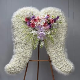 Large white floral standing spray with pink and purple roses and orchids