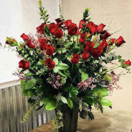 Tall bouquet of red roses in a clear glass vase