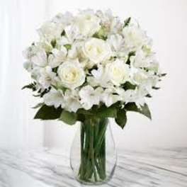 White roses and lilies in a clear glass vase