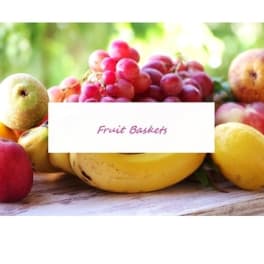 Assorted fruit with grapes and apples around a fruit baskets label