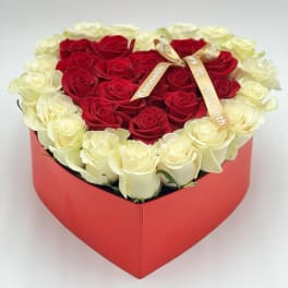 Heart-shaped box of red and white roses with a ribbon