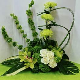 Green floral arrangement with white roses and orchids