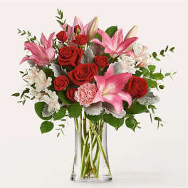 Pink lilies and red roses in a clear glass vase