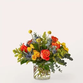 Mixed bouquet of orange and yellow roses in a clear glass vase