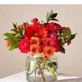 Bouquet of red and orange flowers in a clear glass vase