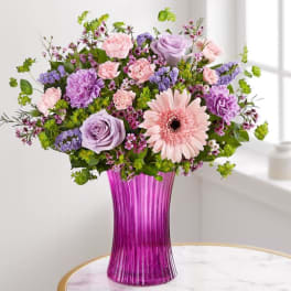 Mixed pink and lavender flowers in a tall purple vase