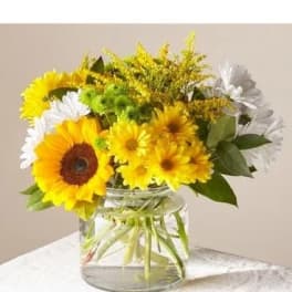Sunflowers and white daisies in a clear glass vase