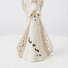 Cream-colored angel figurine with cutout details