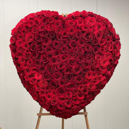 Heart-shaped arrangement of red roses on an easel