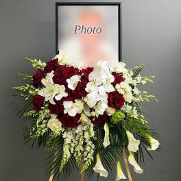 Standing floral spray with red roses, white orchids, and white calla lilies