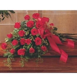 Bouquet of red roses with a red ribbon on a wooden surface