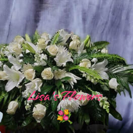 White floral spray with lilies and roses against a purple backdrop